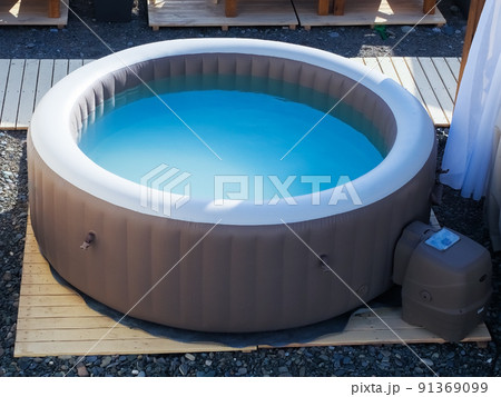 Inflatable brown and white swimming pool with turquoise water outdoors in the summer sun at the beach recreation area Inflatable brown and white swimming pool with turquoise water outdoors in the summer sun at the beach recreation area 91369099