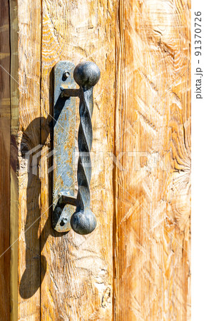 Forged handmade door handle on the wooden door Forged handmade door handle on the wooden door 91370726