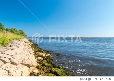Stony riverbank near Vistula estuary into the Baltic Sea in Sobieszewo island in Gdansk, Poland. Stony riverbank near Vistula estuary into the Baltic Sea in Sobieszewo island in Gdansk, Poland. 91371710