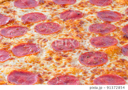 Closeup on salami slices on pizza. 91372854