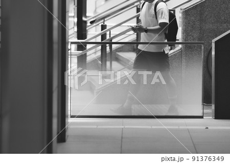 スマホを見ながら歩く人 91376349