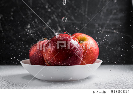 Red apples in a plate of water drops. Red apples in a plate of water drops. 91380814