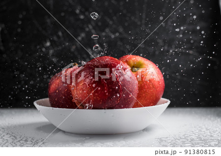 Red apples in a plate of water drops. Red apples in a plate of water drops. 91380815