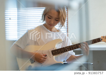 白いエレキギターを弾く若い女性 91383757