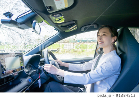 明るい昼間に運転をするジャケット姿の若い女性 91384513