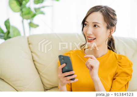 スマホでネットショッピングを楽しむ若い女性 91384523