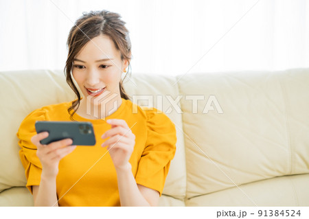 スマホでネットショッピングを楽しむ若い女性 91384524