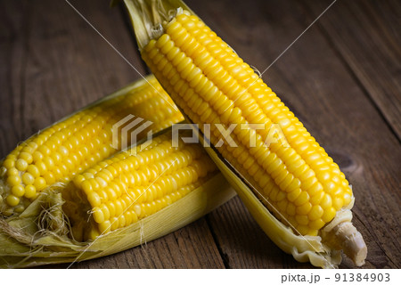 sweet corn cooked on wooden background, ripe corn cobs steamed or boiled sweetcorn for food vegan dinner or snack sweet corn cooked on wooden background, ripe corn cobs steamed or boiled sweetcorn for food vegan dinner or snack 91384903
