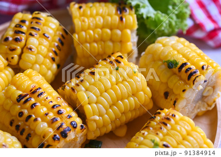 sweet corn food with salad vegetable lime coriander and lettuce, sweet corn cooked on plate background, ripe corn cobs grilled sweetcorn for food vegan dinner or snack 91384914