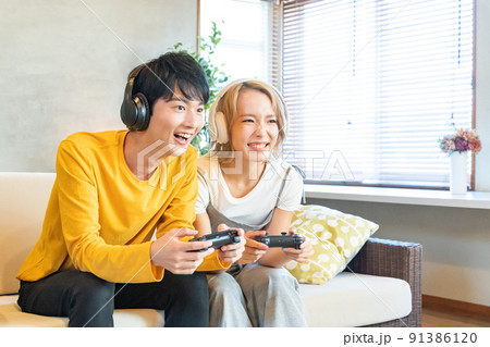 テレビゲームで遊ぶ若い男女 91386120