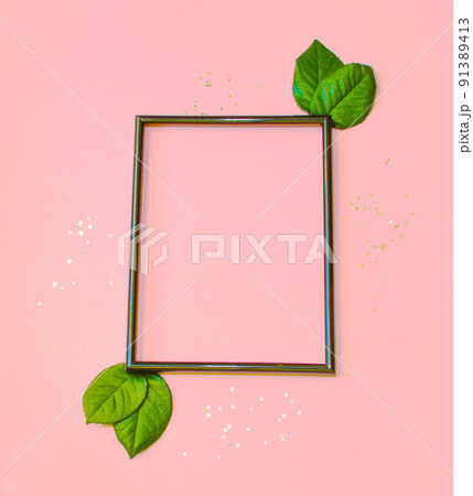 Summer modern composition. Black frame, green leaves on pastel pink background. Flat lay, top view, copy space 91389413