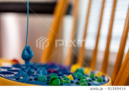 Children's game of using a miniature pole and line lowered into open plastic fish to catch them as the pond spins. Children's game of using a miniature pole and line lowered into open plastic fish to catch them as the pond spins. 91389414