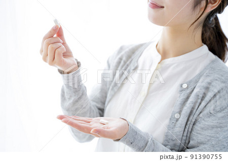 サプリを飲む女性 91390755