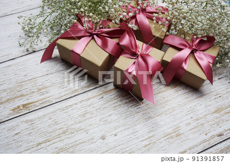 Gift boxes with pink ribbon and flower decoration on wooden background 91391857