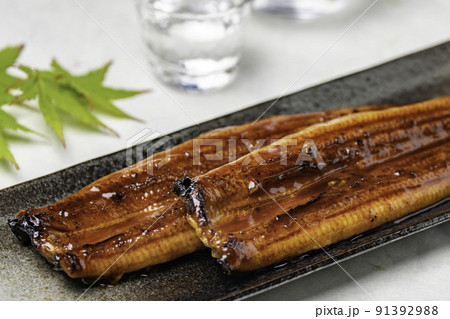長皿に乗った鰻の蒲焼きと紅葉とお冷3 91392988