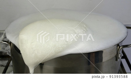 Cows milk boiled and overflowing. Boiling milk escapes from saucepan. Forgot milk on stove. Selective focus. Cows milk boiled and overflowing. Boiling milk escapes from saucepan. Forgot milk on stove. Selective focus. 91393588