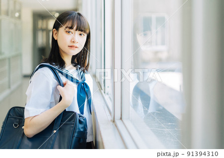 学校の廊下に立つ女子高生 91394310