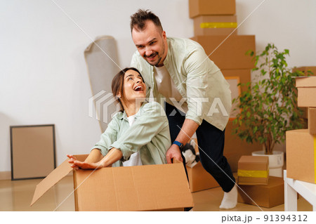 Young happy couple in room with moving boxes at new home Young happy couple in room with moving boxes at new home 91394312