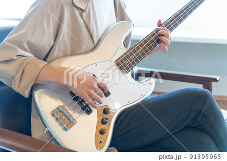 エレキベースを弾く若い男性 91395965