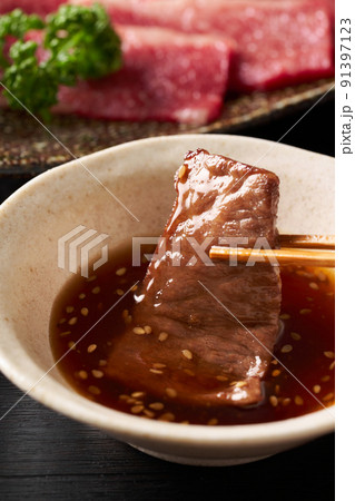 焼肉をタレに漬ける 91397123