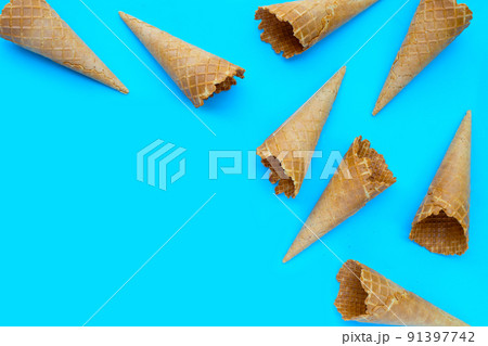 Empty ice cream cone on blue background. 91397742