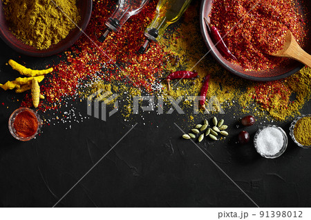 Set of indian spices on black background - green cardamom, turmeric powder, coriander seeds, cumin, and chili, top view Set of indian spices on black background - green cardamom, turmeric powder, coriander seeds, cumin, and chili, top view 91398012