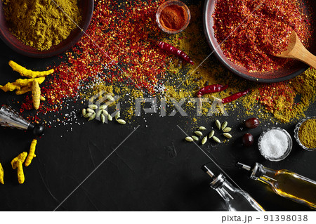 Set of indian spices on black background - green cardamom, turmeric powder, coriander seeds, cumin, and chili, top view Set of indian spices on black background - green cardamom, turmeric powder, coriander seeds, cumin, and chili, top view 91398038