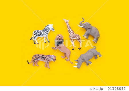 Plastic jungle animal toys on yellow background. 91398052