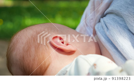 Little breastfed baby has easy breakfast in green park Little breastfed baby has easy breakfast in green park 91398223