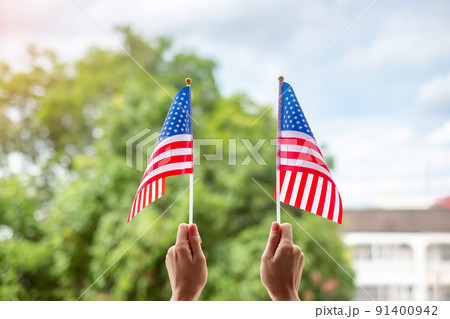 hand holding United States of America flag on green background. USA holiday of Veterans, Memorial, Independence ( Fourth of July) and Labor Day concept hand holding United States of America flag on green background. USA holiday of Veterans, Memorial, Independence ( Fourth of July) and Labor Day concept 91400942
