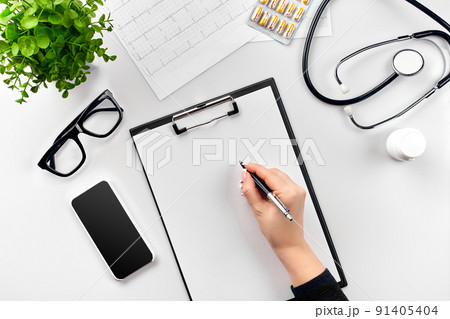 Doctor's work with stethoscope and copybook on hospital desk background. Top view 91405404