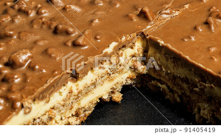 Slice of Swedish almond and chocolate cake with filling and nuts 91405419