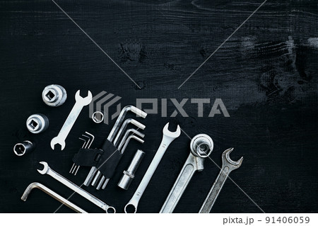 Flat lay of set of tools for car repairing such as wrenches on black wooden background. Top view. Flat lay of set of tools for car repairing such as wrenches on black wooden background. Top view. 91406059