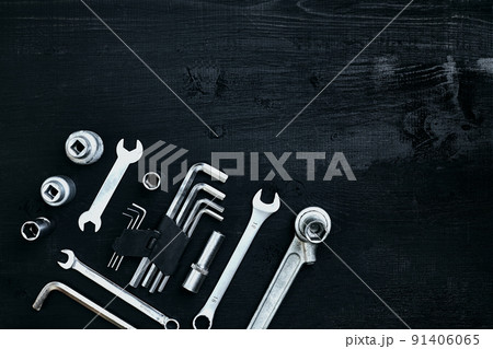 Flat lay of set of tools for car repairing such as wrenches on black wooden background. Top view. Flat lay of set of tools for car repairing such as wrenches on black wooden background. Top view. 91406065