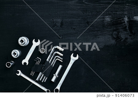 Flat lay of set of tools for car repairing such as wrenches on black wooden background. Top view. 91406073