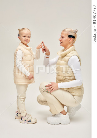 Woman with little girl in futuristic costume wearing smart led glasses of virtual reality while touching air. Augmented reality game, future technology, AI concept. VR. 91407737