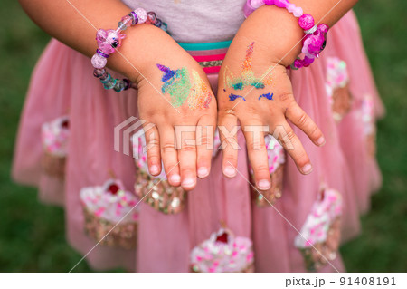 Shimmering sparkling glitter tattoo on a child's hand at a birthday party Shimmering sparkling glitter tattoo on a child's hand at a birthday party 91408191