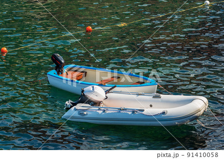 Two Empty Small Recreational Motor Boats moored in a Port 91410058