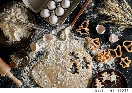 Dough for ginger biscuits rolled up on a table and cut using molds Dough for ginger biscuits rolled up on a table and cut using molds 91411058