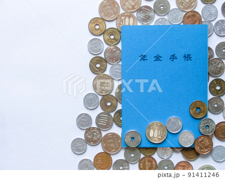 散らばった日本の硬貨と青色の年金手帳に白背景のコピースペース 散らばった日本の硬貨と青色の年金手帳に白背景のコピースペース 91411246
