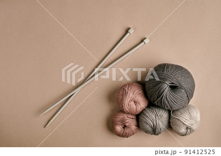 Knitted from a gray yarn sweater and thread for knitting closeup. Knitting as a hobby. Accessories for knitting. 91412525