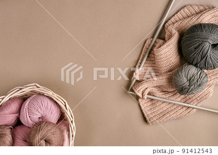 Balls of merino wool yarn, knitting on knitting needles on a beige surface. Top view Balls of merino wool yarn, knitting on knitting needles on a beige surface. Top view 91412543