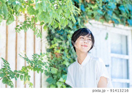 新緑のテラスでリフレッシュする若い女性 新緑のテラスでリフレッシュする若い女性 91413216
