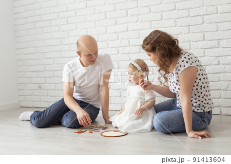 Child girl with cochlear implant plays at home with mother and father. Hear impairment and diversity and hearing aid 91413604