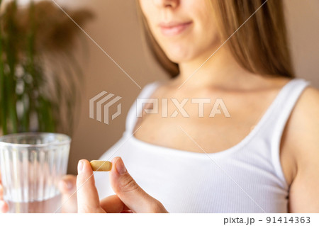 Supplements vitamins pill. Happy young pregnant woman holding supplement vitamin pill. Therapy, healthcare, motherhood concept. Supplements vitamins pill. Happy young pregnant woman holding supplement vitamin pill. Therapy, healthcare, motherhood concept. 91414363