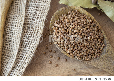 Buckwheat tea in a wooden spoon on a light wooden background. buckwheat porridge on a wooden spoon Buckwheat tea in a wooden spoon on a light wooden background. buckwheat porridge on a wooden spoon 91414536