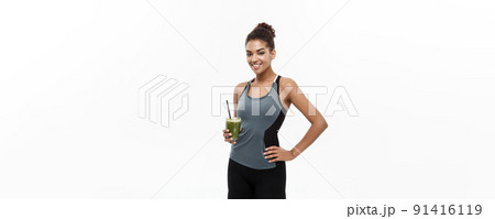 Healthy and Fitness concept - beautiful African American girl in sport clothes holding plastic water bottle after workout. Isolated on white studio background 91416119