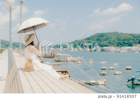 ワンピース姿の女性と夏空 91418507