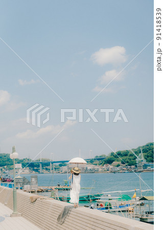 ワンピース姿の女性と夏空 91418539