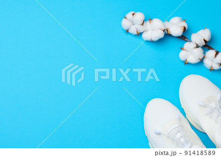 White textile sneakers on a blue background, top view White textile sneakers on a blue background, top view 91418589